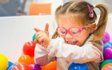 Beatrice, a young girl with LCA10, playing in a ball bath