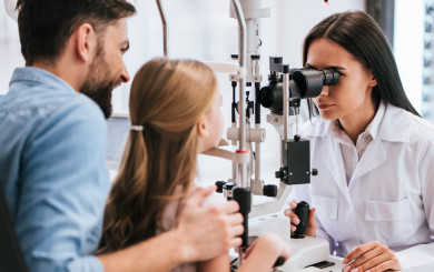 Young girl gets her eyes tested by a clinician