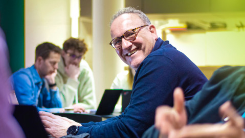 Rene Beukema smiling and looking up from his work