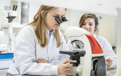 ProQRians looking through a microscope in the lab