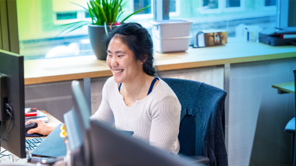 Employee sitting at their desk and smiling