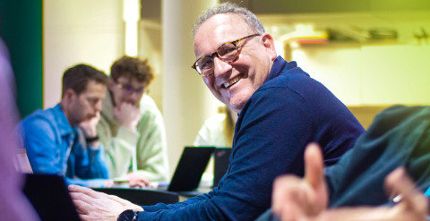 Rene Beukema smiling and looking up from his work