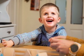 Young boy, living with LCA, playing with special toys for blind kids