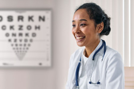Ophthalmologist at her office with logmar chart on wall