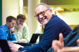 Rene Beukema smiling and looking up from his work