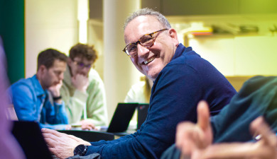 Rene Beukema smiling and looking up from his work